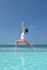 Fototapeta na wymiar Asian chinese woman practising yoga by the sea