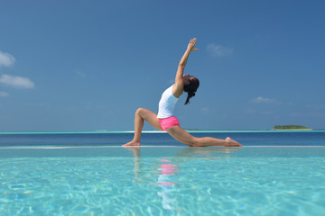 Fototapeta na wymiar Asian chinese woman practising yoga by the sea