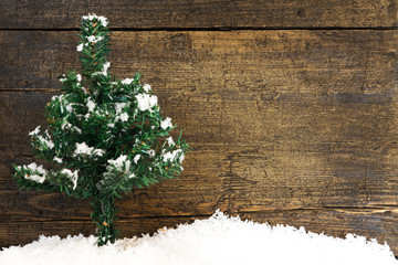 winterliche Karte mit Tannenbaum und Schnee vor Holz
