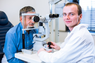 Optometry concept - senior man having his eyes examined