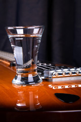 Glass of tequila on the electric guitar