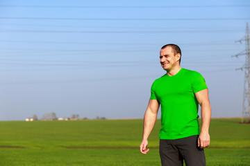 happy farmer (businessman) standing in wheat field over wind tur