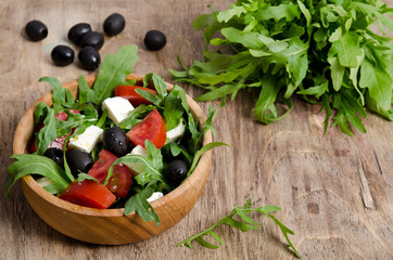 Greek salad in a wooden salad bowl on the table