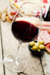 Glass of red wine with charcuterie assortment on the background