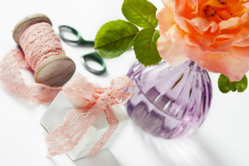 Decorated gift box and rose in vase on white