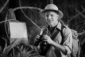 Adventurer in the jungle with binoculars