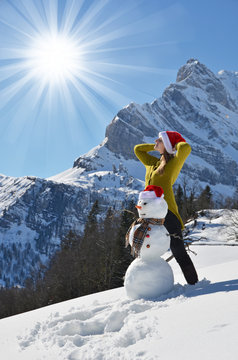 Girl decorating a snowman