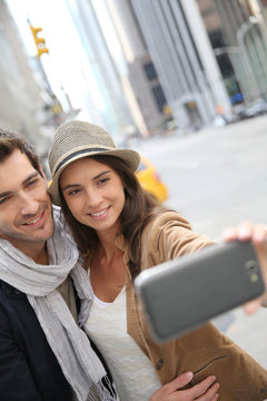 Couple in Manhattan taking picture with smartphone