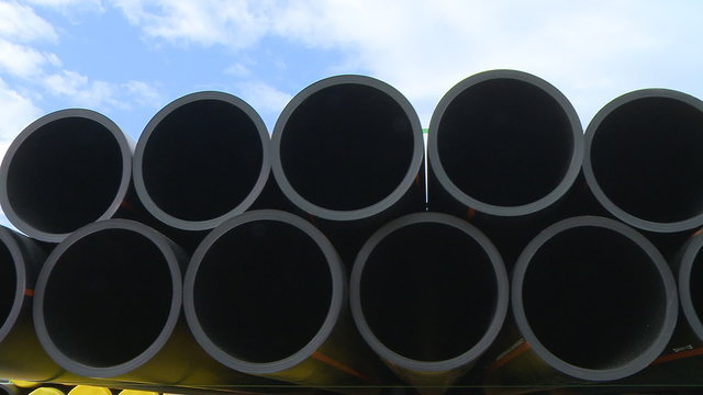 Pipes stacked in construction site dolly shot