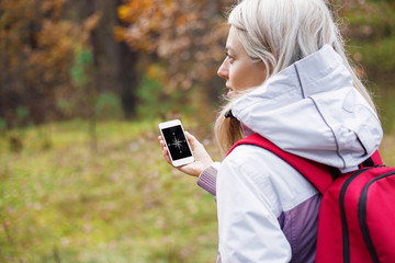 Woman checking compass app on her smartphone