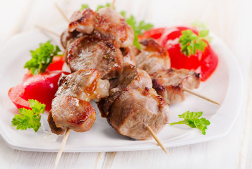 Kebabs served with vegetables on  white plate