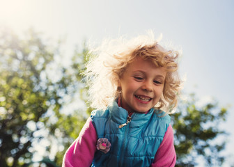 Portrait of cute blonde little girl playing outdoors
