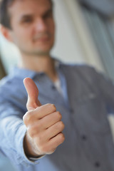 man in shirt shows thumb closeup
