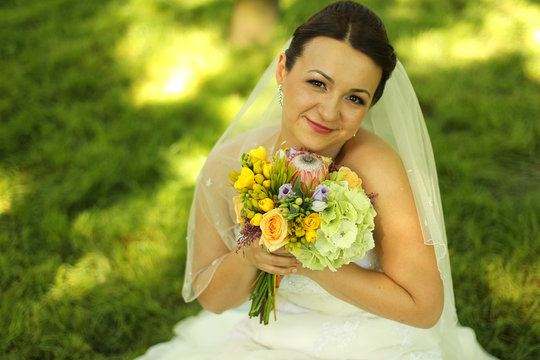 beautiful bride in park with flowers