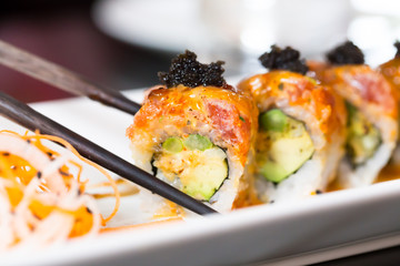 Sushi roll with black chopsticks