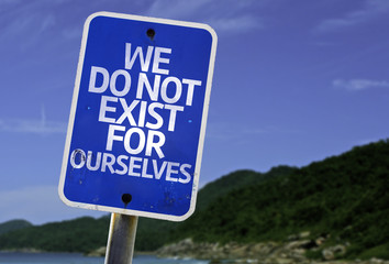 We Do Not Exist for Ourselves sign with a beach