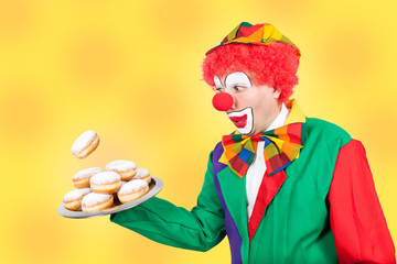 clown mit pfannkuchen vor gelbem hintergrund