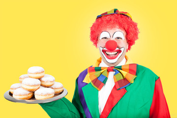 clown mit pfannkuchen vor gelbem hintergrund - obrazy, fototapety, plakaty
