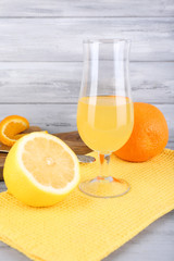 glass of juice with fresh fruits on grey wooden table