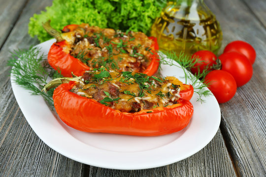 Stuffed red peppers with greens and vegetables on table close