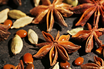Stars anise and cardamom on wooden background