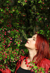 Young redhead woman enjoying cherry blossom in the spring sunshi