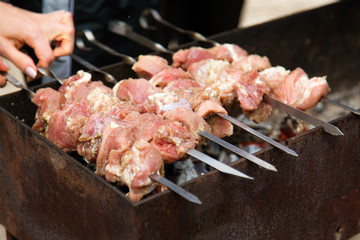 Marinated shashlik, meat grilling on metal skewer, close up