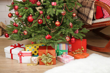 Fototapeta na wymiar Decorated Christmas tree with gifts in room closeup