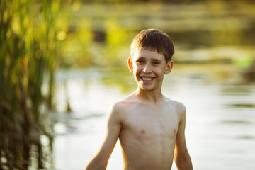 Happy little boy standing in water