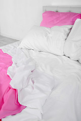 Crumpled pink linen on bed