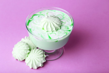 Mint milk dessert in glass bowl on color background