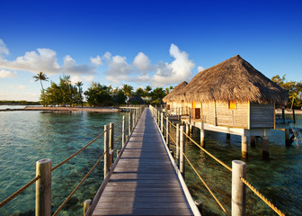The wooden road over the sea to the tropical island.