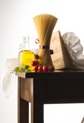 Spaghetti and olive oil and tomato on the wooden table