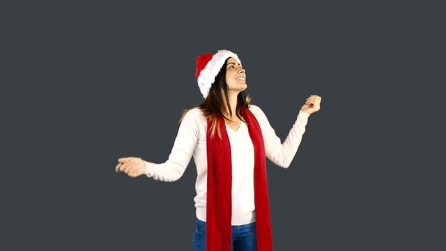 Woman in santa hat and warm clothing looking upwards