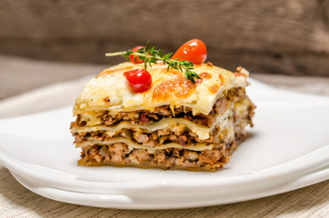 Portion of lasagna on the wooden table