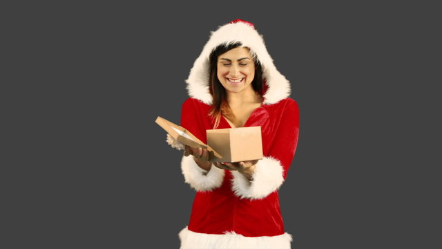 Sexy girl in santa costume opening a gift