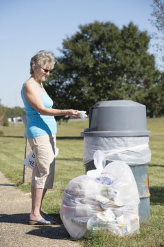 Woman using a rubbish bin to dispose of her garbage
