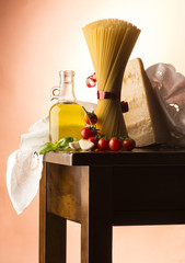 Spaghetti and olive oil and tomato on the wooden table