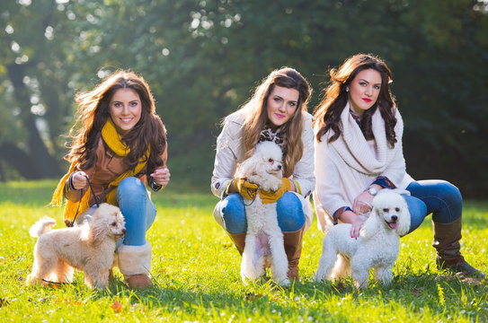 Three Young Woman With Their Pet Dogs In The Park