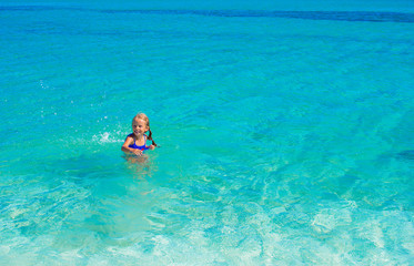 Adorable little girl have fun at tropical beach