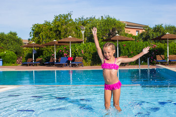 Adorable happy little girl enjoy swimming in the pool