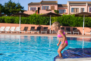 Cute happy little girl having fun in the swimming pool