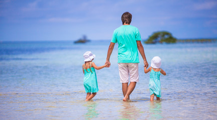 Naklejka premium Adorable little girls and young father during beach vacation