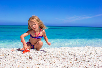 Adorable little girl at tropical beach during summer vacation