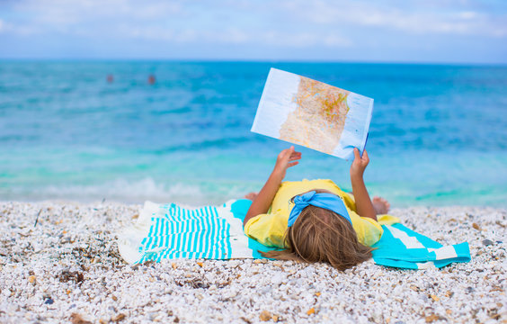 Adorable little girl with map find the way on tropical beach