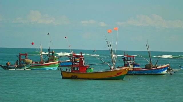 Several small vessels are laid up in a calm bay ocean