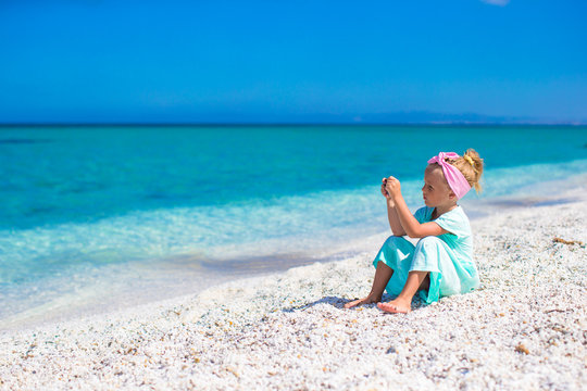 Little adorable girl take picture of the sea on phone at