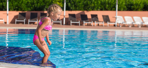 Adorable happy little girl enjoy swimming in the pool