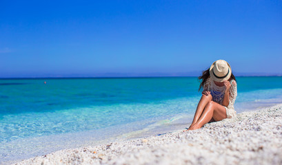 Young beautiful girl during summer vacation on white beach