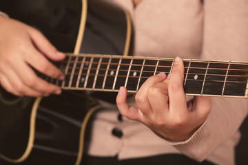 Fototapeta na wymiar Acoustic guitar in female hands, close-up
